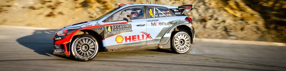 Une voiture de rallye en dérapage sur une route du championnat du monde des rallyes