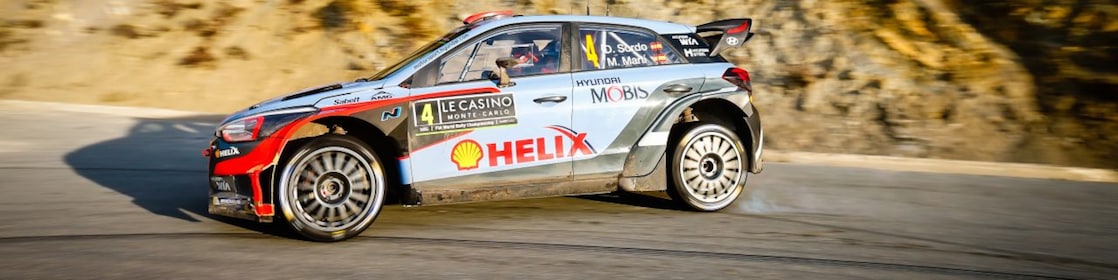 Une voiture de rallye en dérapage sur une route du championnat du monde des rallyes