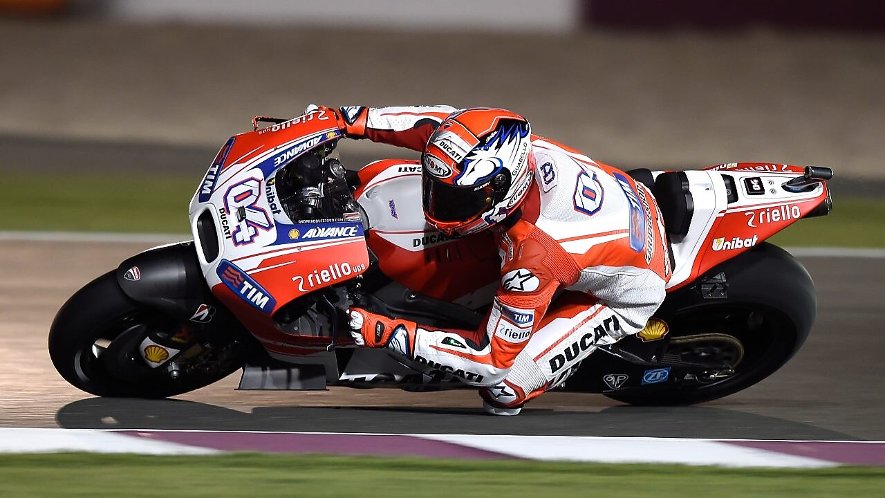 Un pilote sur une moto faisant le tour d'un coin de la piste