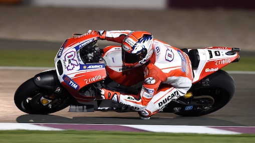 Un pilote sur une moto faisant le tour d'un coin de la piste
