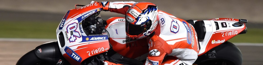 Un pilote sur une moto faisant le tour d'un coin de la piste